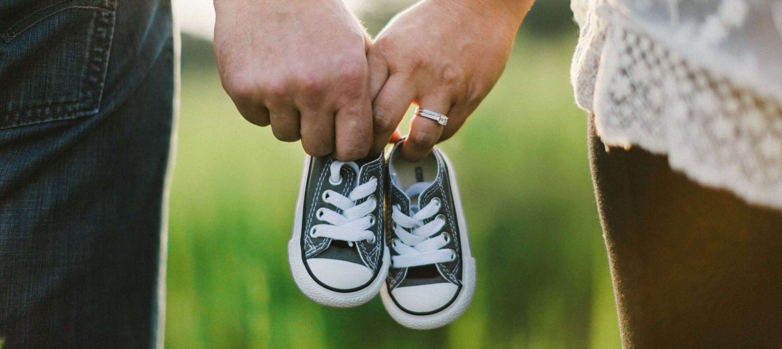 Aanstaande ouders houden kleine babyschoentjes vast