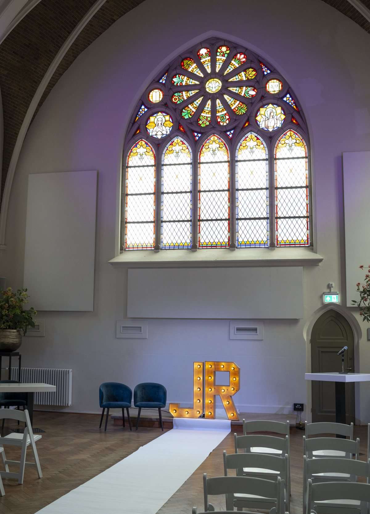 De Kapittelzaal ingericht voor een ceremonie, met stoelen, loper en het rozetraam