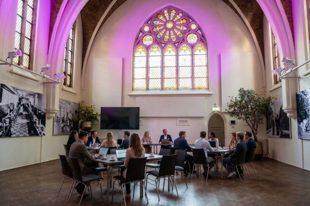 De Kapittelzaal bij Hemels, ingericht voor een vergadering met hoge plafonds en daglicht